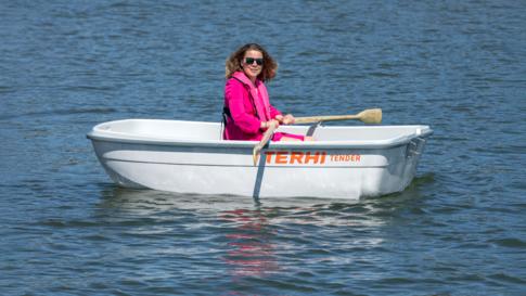 A woman rowing the Terhi Tender catamaran dinghy.