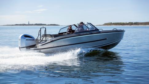 Kaksi miestä ajaa Silver Seahawk BRX -alumiiniveneellä kovaa vauhtia. Merivesi pärskyy, mutta miehet ovat tuulilasin takana suojassa.